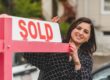 Real estate agent with sold sign