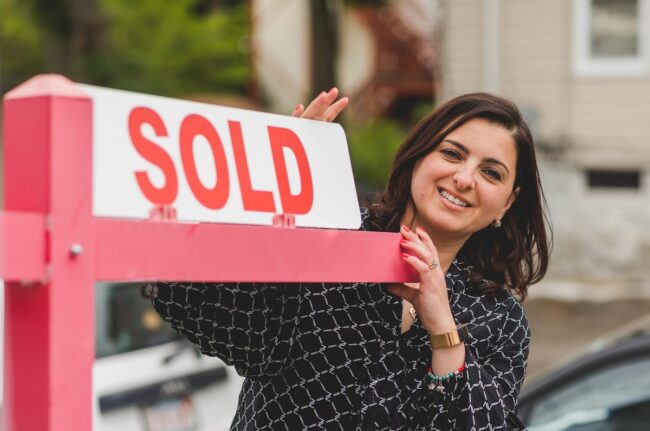 Real estate agent with sold sign