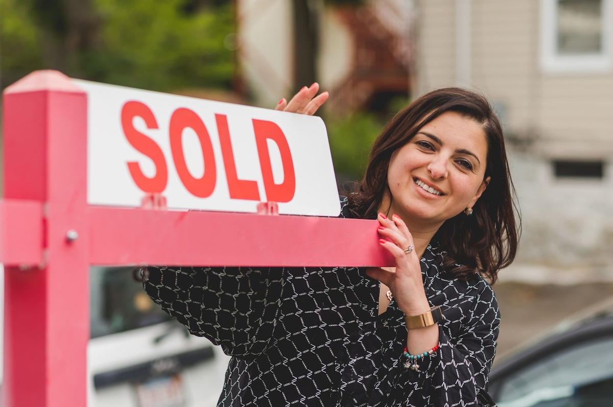 Real estate agent with sold sign