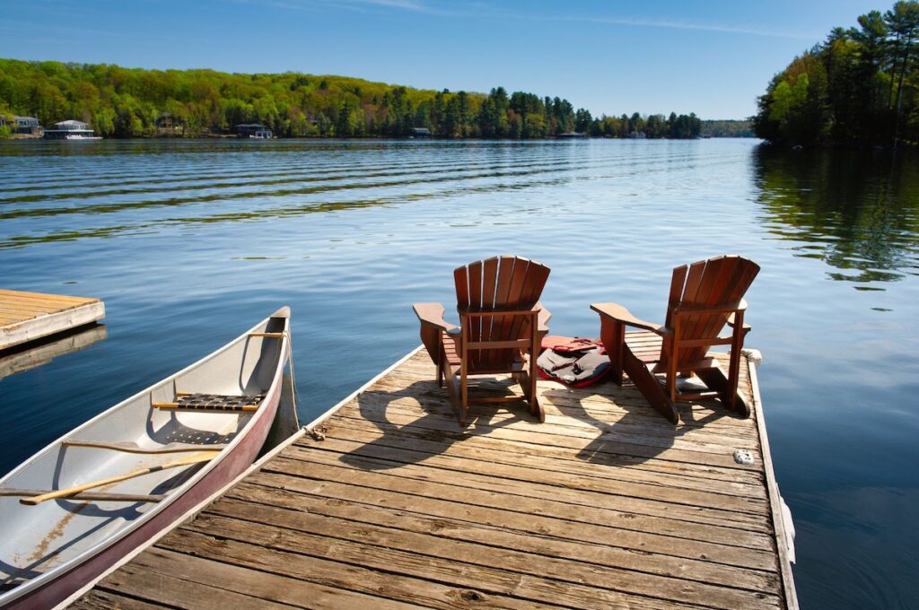 Dock on a lake with chairs and a canoe