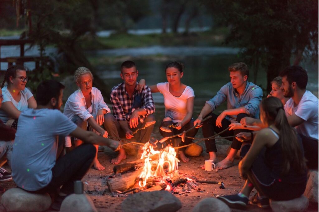 Group around a fire pit at the lake