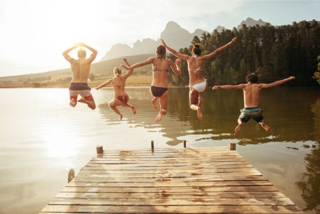 Friends jumping from the pier together